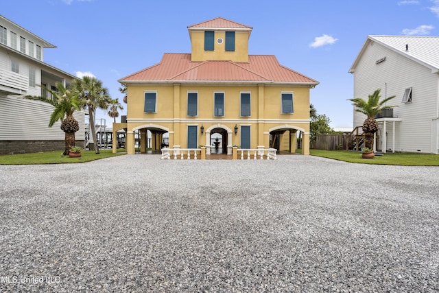 view of front of property with driveway, stucco siding, a carport, and metal roof