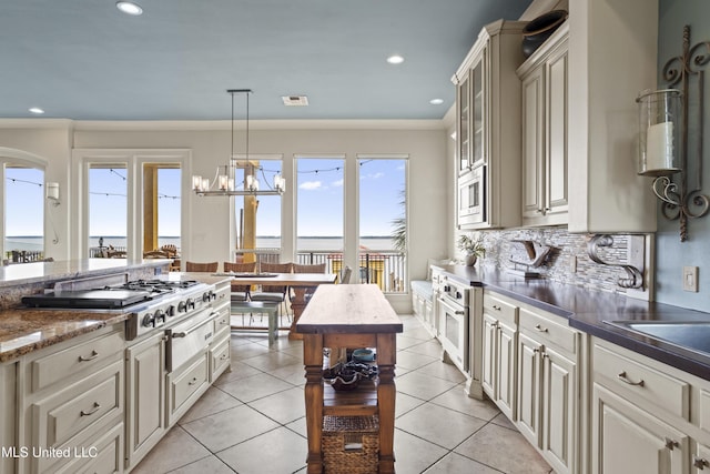 kitchen featuring appliances with stainless steel finishes, healthy amount of natural light, glass insert cabinets, hanging light fixtures, and recessed lighting