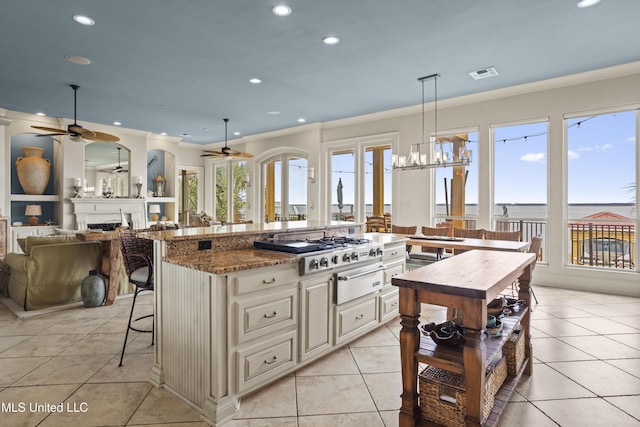 kitchen with ceiling fan, recessed lighting, cooktop, a warming drawer, and a breakfast bar area
