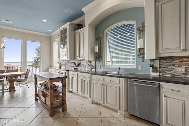 kitchen with appliances with stainless steel finishes, a sink, dark countertops, backsplash, and recessed lighting