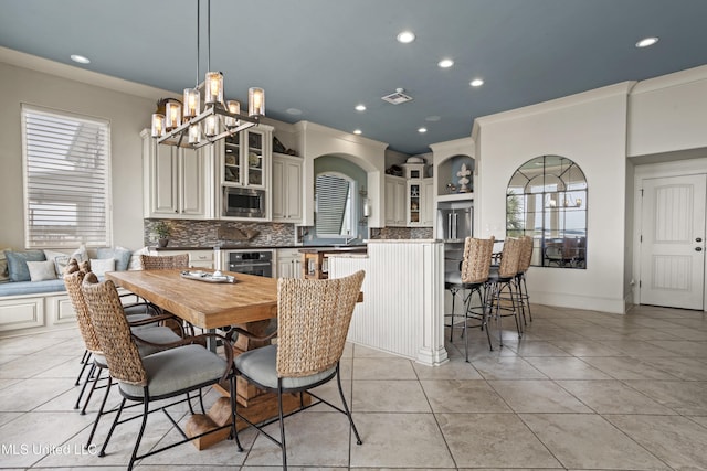 dining area with light tile patterned flooring, a chandelier, recessed lighting, and arched walkways