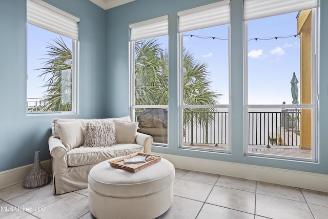 sunroom with tile patterned floors, crown molding, and baseboards