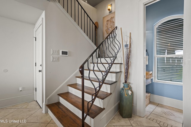 stairs featuring baseboards and tile patterned flooring