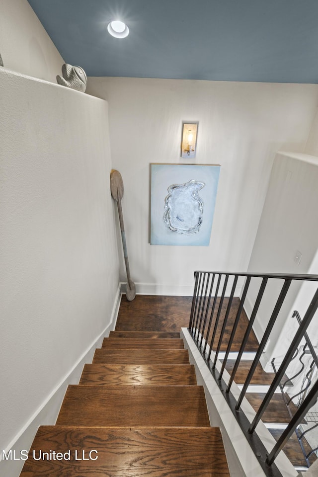 staircase with wood finished floors and baseboards