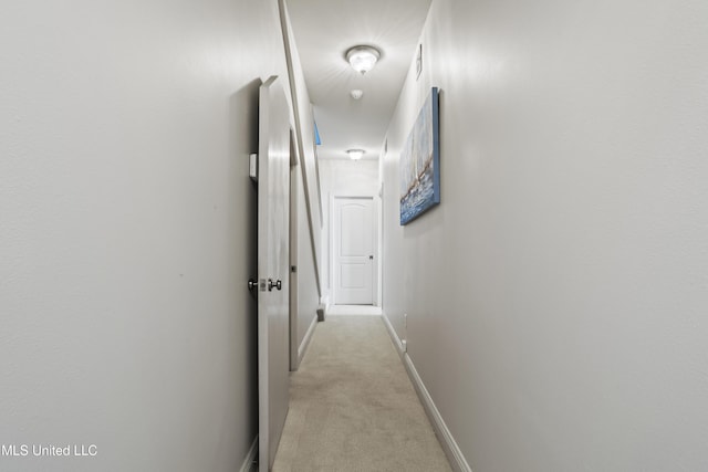 corridor with light colored carpet and baseboards