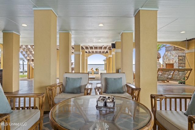 dining space featuring ornate columns, recessed lighting, and a water view