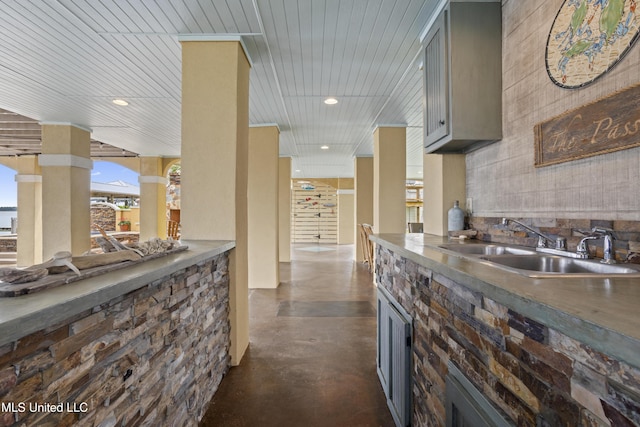 kitchen with a sink, finished concrete flooring, recessed lighting, and gray cabinetry