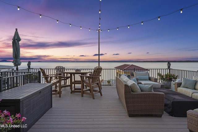wooden terrace featuring an outdoor hangout area and a water view