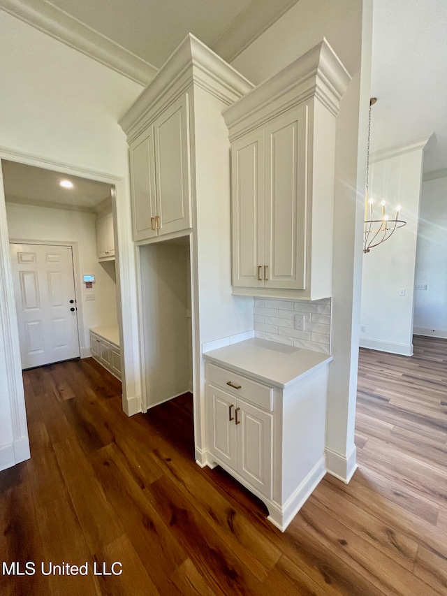 kitchen featuring decorative backsplash, dark wood-type flooring, and a chandelier