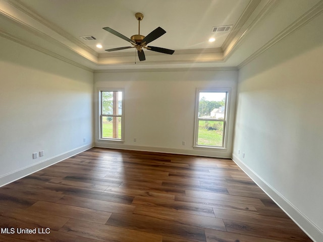 spare room with dark hardwood / wood-style flooring, ornamental molding, and a wealth of natural light