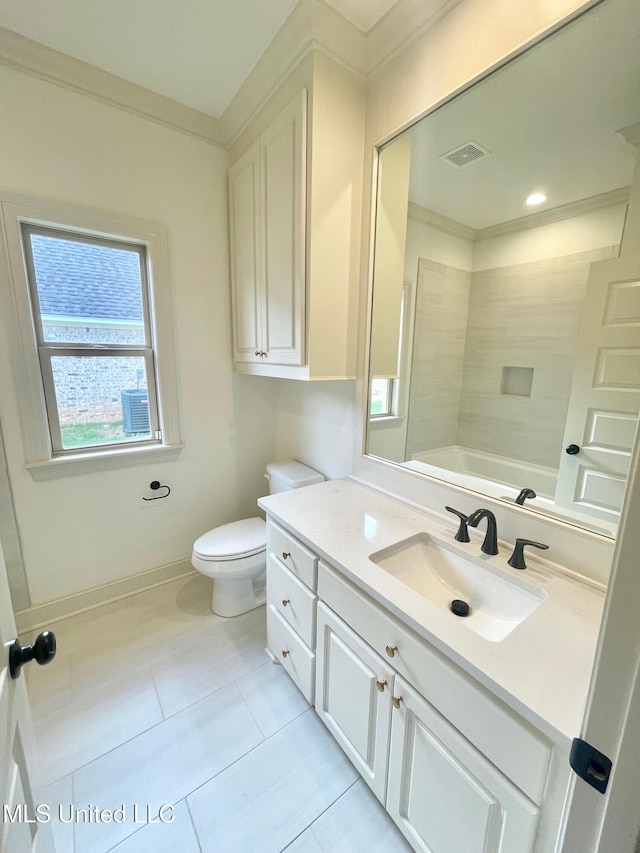 full bathroom with tile patterned flooring, crown molding, toilet, vanity, and tiled shower / bath