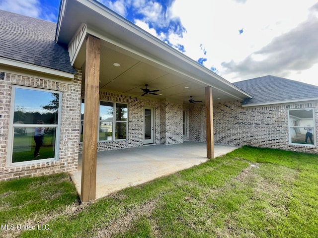 rear view of house featuring a patio, ceiling fan, and a lawn