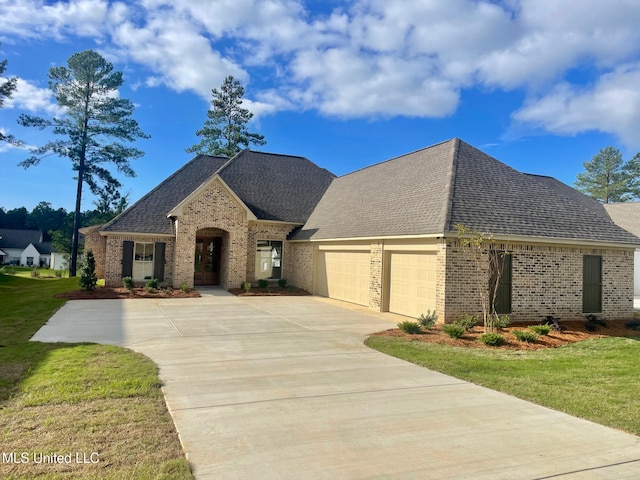 french country inspired facade featuring a garage and a front lawn