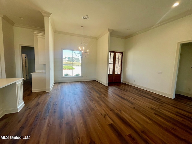 unfurnished dining area with dark hardwood / wood-style flooring, ornamental molding, and a notable chandelier