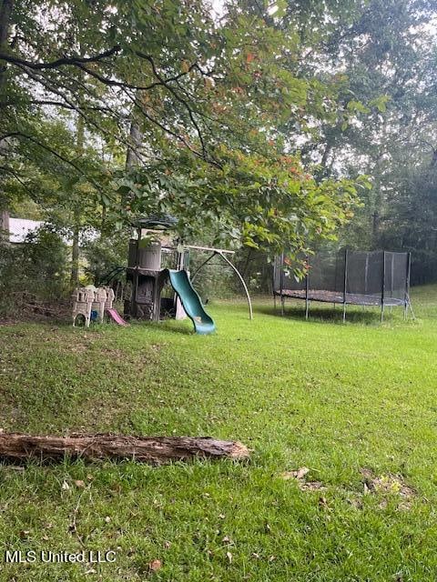 view of yard with a playground and a trampoline