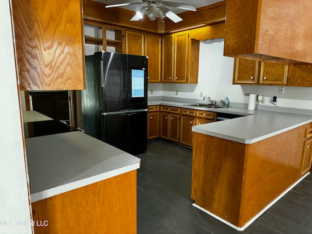 kitchen with kitchen peninsula, sink, ceiling fan, and black refrigerator