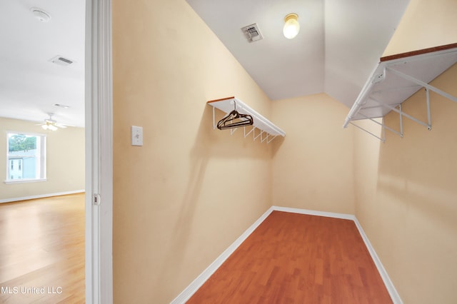 walk in closet featuring wood-type flooring and ceiling fan