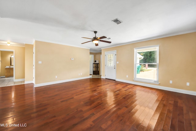 unfurnished living room with ornamental molding, visible vents, baseboards, and hardwood / wood-style flooring