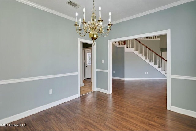 spare room featuring a notable chandelier, wood finished floors, visible vents, baseboards, and crown molding