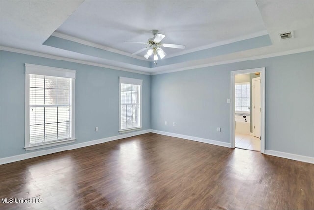 unfurnished room with dark wood-style floors, a raised ceiling, visible vents, and baseboards