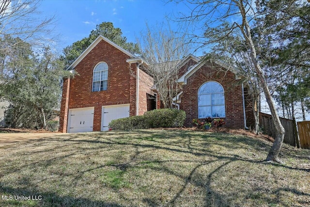 view of front of home with a garage, brick siding, a front yard, and fence