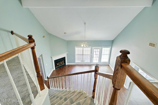 stairway with baseboards, a fireplace, visible vents, and wood finished floors