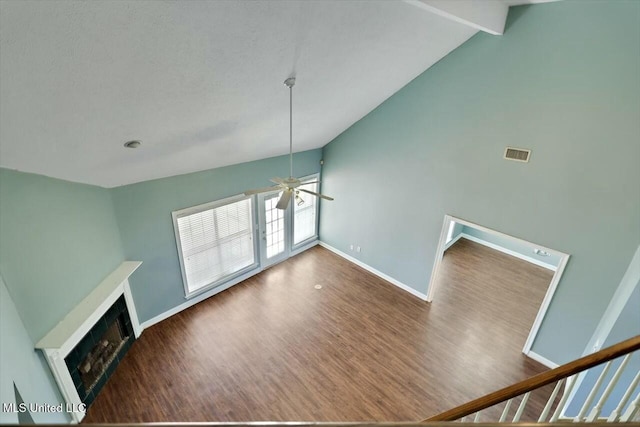 unfurnished living room with ceiling fan, a fireplace, wood finished floors, visible vents, and baseboards