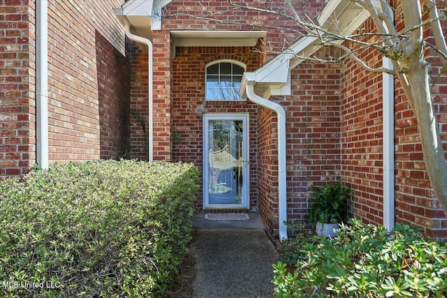 doorway to property featuring brick siding