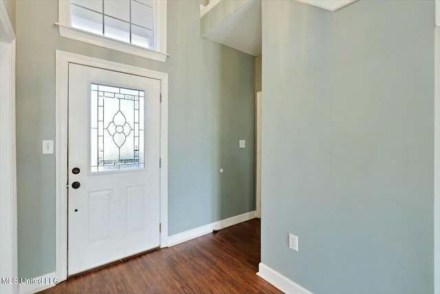 foyer entrance with dark wood finished floors and baseboards