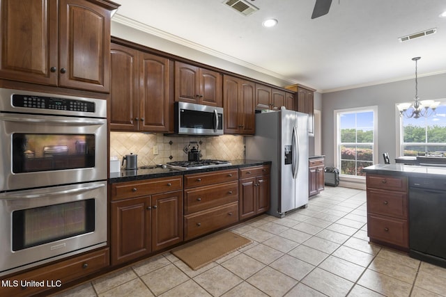 1600 Wright Rd, Raymond, MS 39154 - kitchen featuring appliances with stainless steel finishes, ornamental molding, dark countertops, tasteful backsplash, and a chandelier