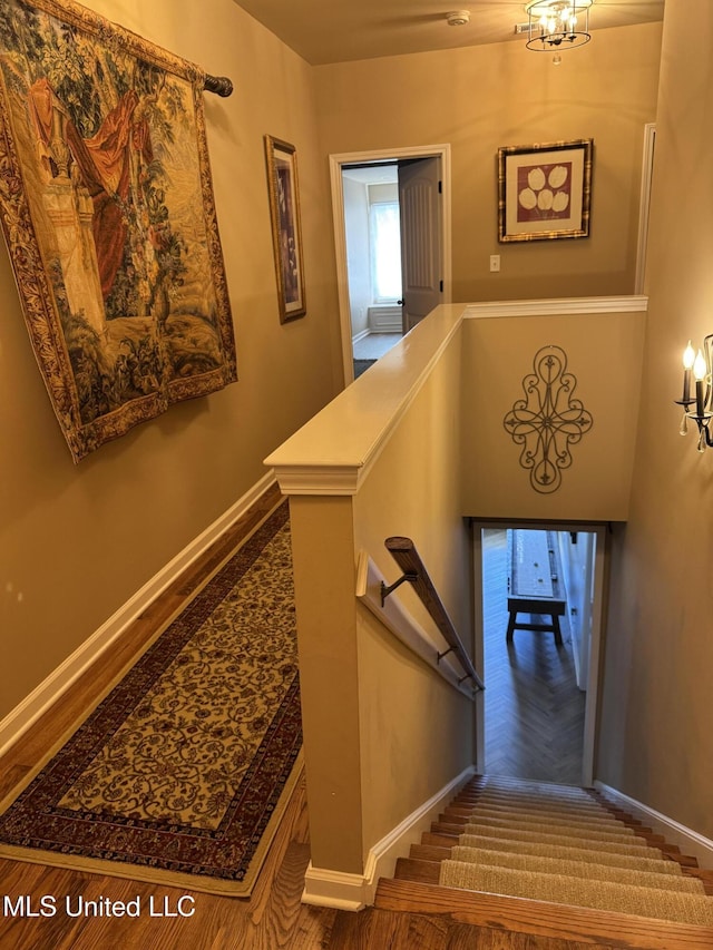 stairway with a chandelier and baseboards