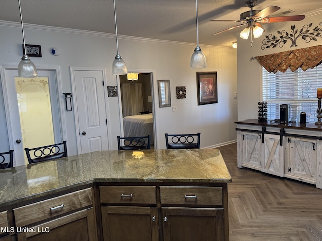 kitchen with hanging light fixtures, dark brown cabinetry, ornamental molding, and a textured ceiling