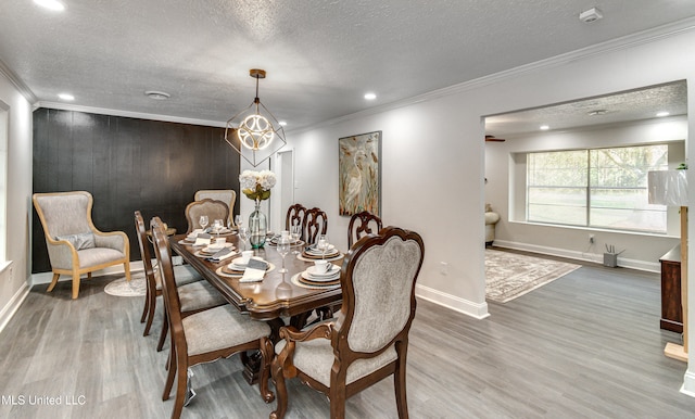 dining space featuring hardwood / wood-style floors, a textured ceiling, and ornamental molding