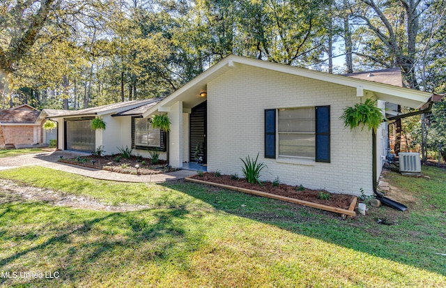 ranch-style home featuring central AC unit and a front lawn