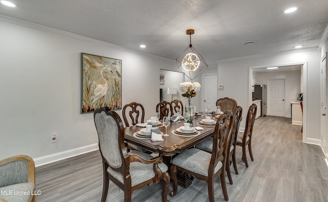 dining room featuring hardwood / wood-style floors, a textured ceiling, and ornamental molding