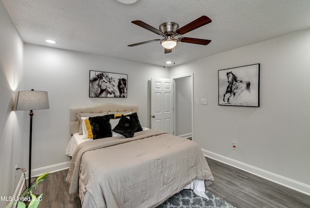 bedroom with ceiling fan, dark hardwood / wood-style floors, and a textured ceiling