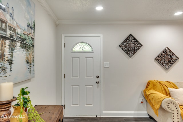 entrance foyer featuring ornamental molding, a textured ceiling, and dark wood-type flooring