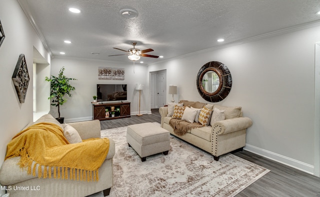 living room with hardwood / wood-style floors, ceiling fan, crown molding, and a textured ceiling