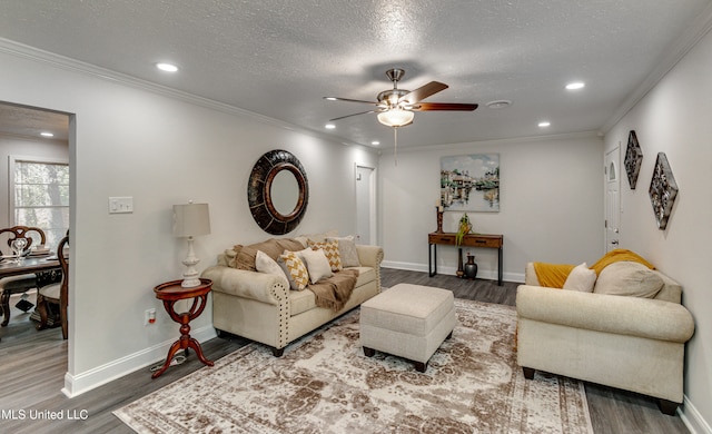 living room with hardwood / wood-style floors, ceiling fan, and ornamental molding