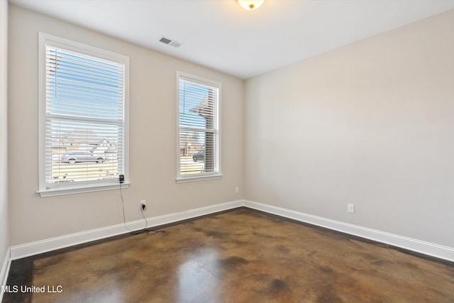 unfurnished room featuring visible vents, concrete floors, and baseboards