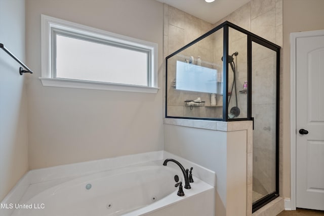 bathroom featuring a shower stall, a tub with jets, and a wealth of natural light