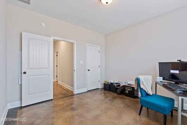 office space with finished concrete floors, visible vents, and baseboards