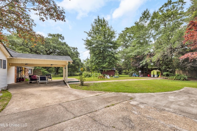 9618 Paige Bayou Rd, Vancleave, MS 39565 - view of grassy yard featuring driveway, an attached carport, and a patio