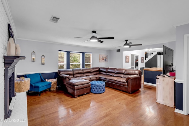9618 Paige Bayou Rd, Vancleave, MS 39565 - living area with a fireplace, wood finished floors, a ceiling fan, ornamental molding, and stairs