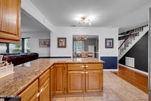 9618 Paige Bayou Rd, Vancleave, MS 39565 - kitchen with ornamental molding, healthy amount of natural light, light stone counters, light tile patterned floors, and a chandelier