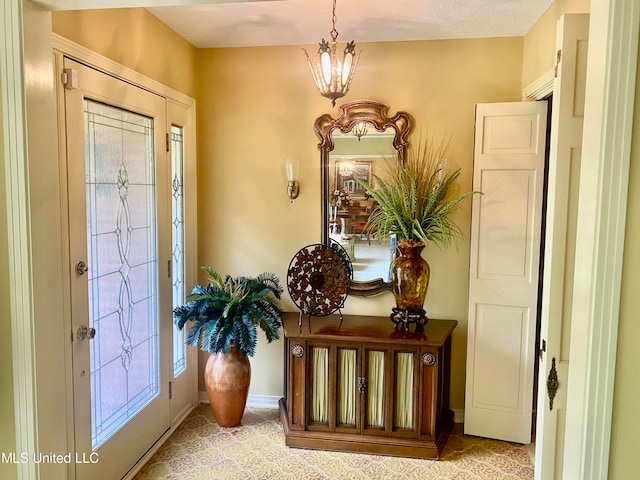 carpeted foyer entrance featuring an inviting chandelier