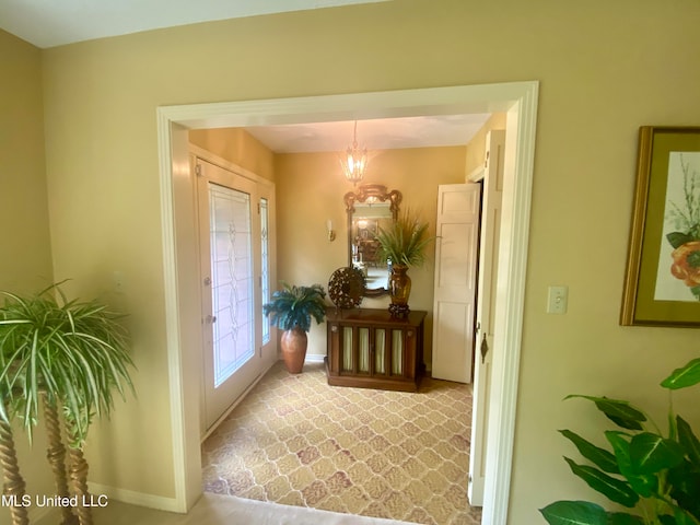 foyer with a notable chandelier and carpet