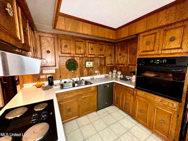 kitchen with sink, black appliances, crown molding, and wood walls