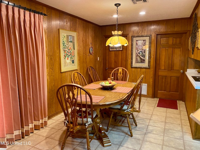 dining room with crown molding and wooden walls