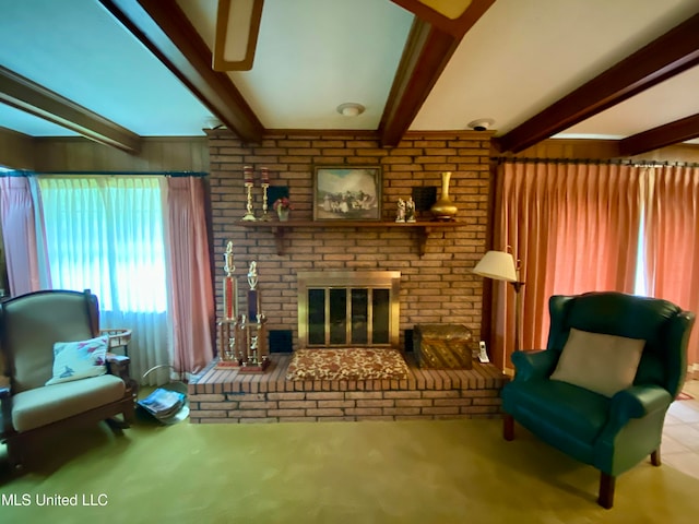 carpeted living room with beamed ceiling and a brick fireplace